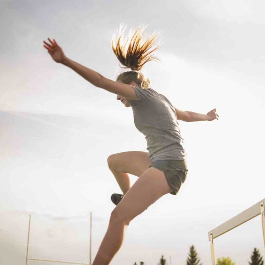 Young Woman Jumping A Hurdle