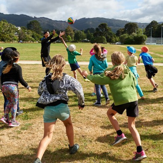 A group of kids playing ball game in a field