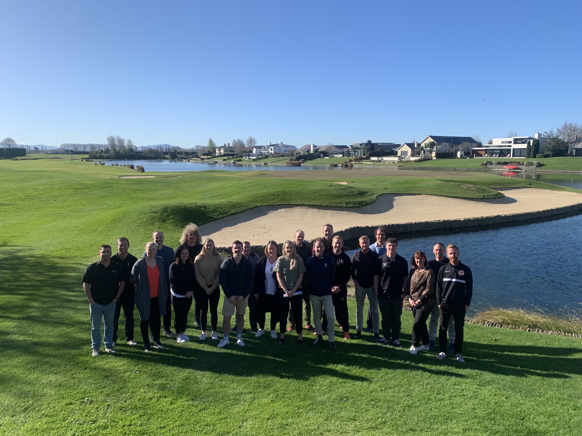 Group of people standing on a golf course