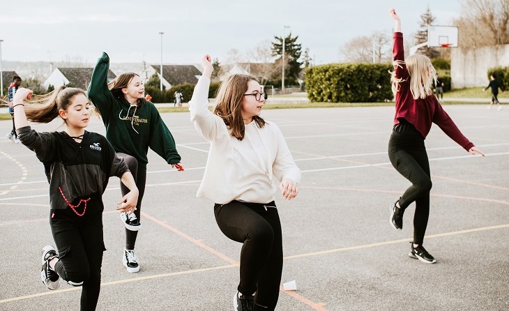 Group of rangatahi women doing a dance on a court