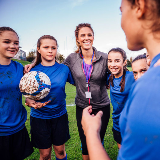 Coach talking to their team in a huddle
