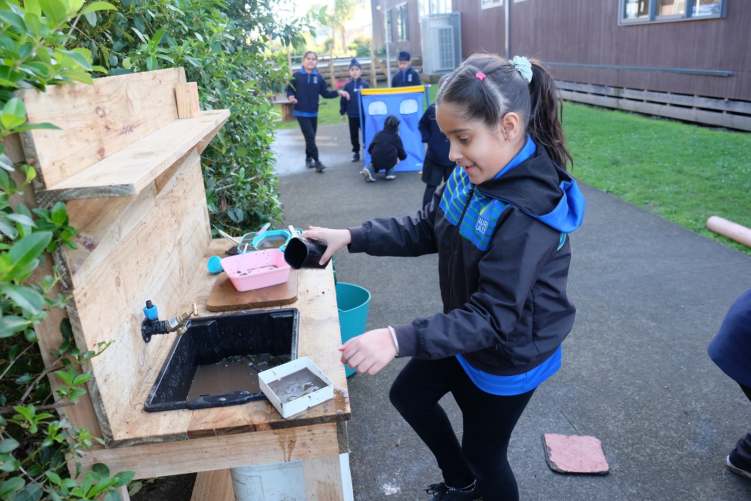 Tamariki playing at a mud kitchen