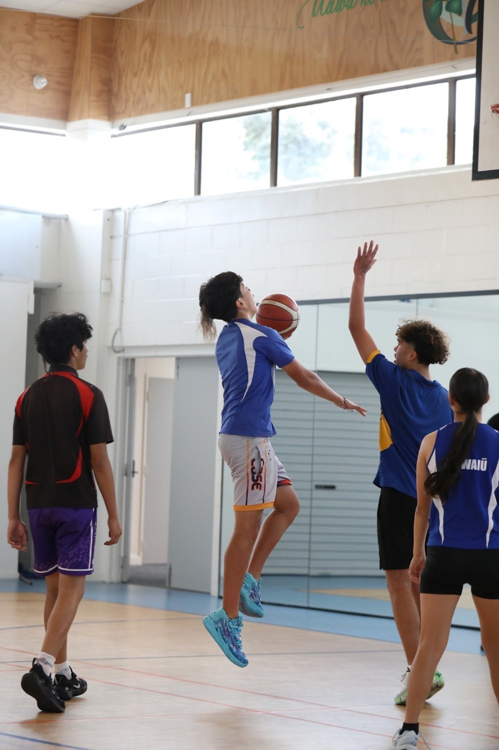 Basketball player jumping to shoot a hoop