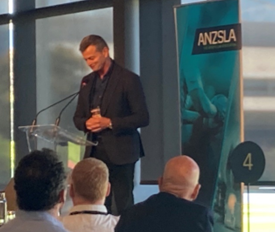 Don Mackinnon standing in front of a croud at a conference