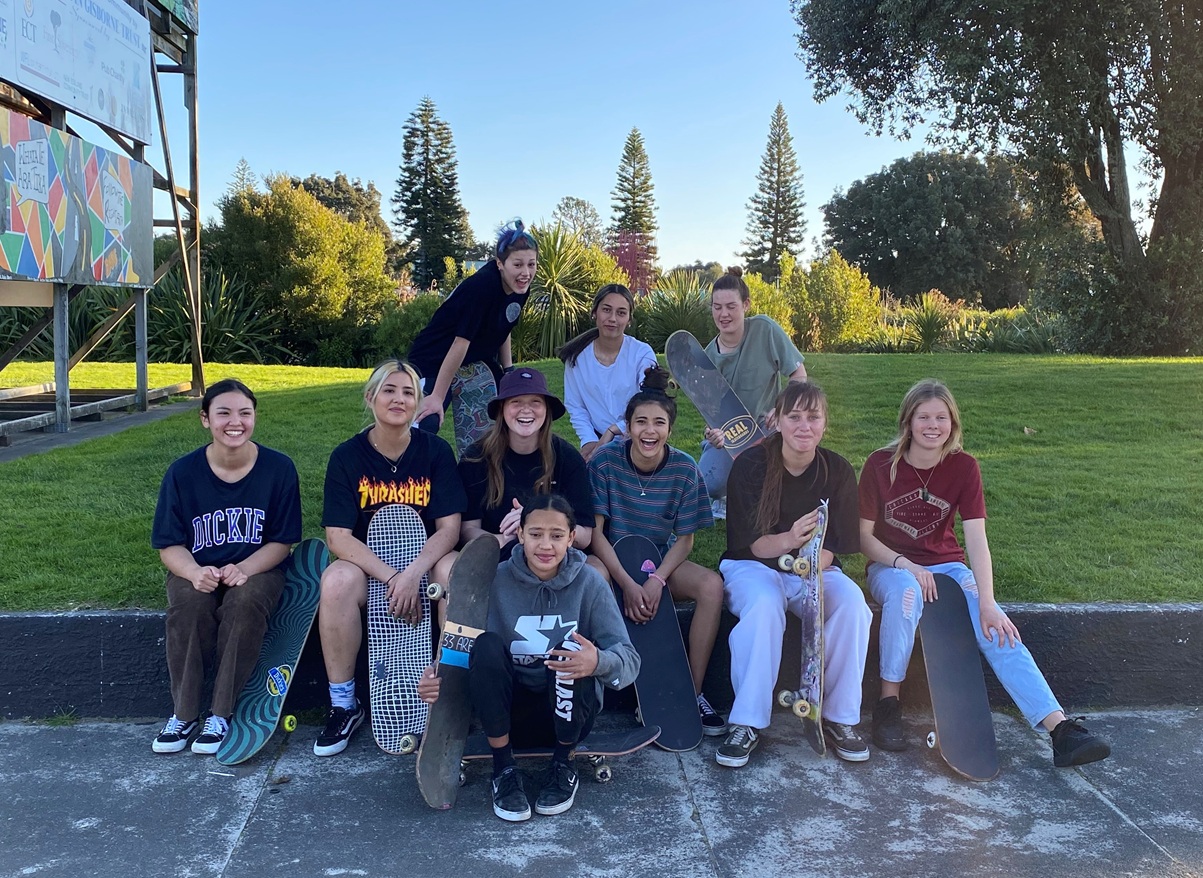 Group of young women skateboarders smiling at camera