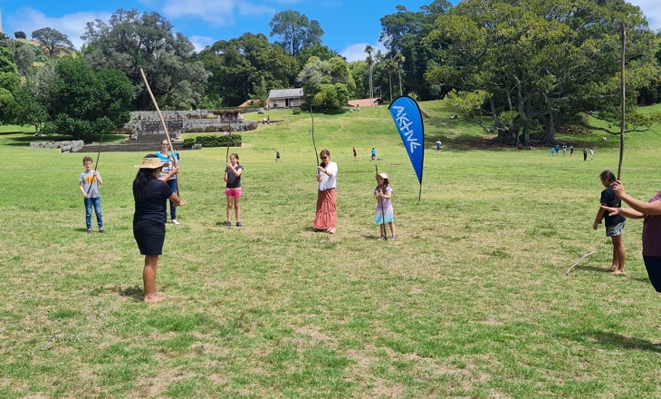 People doing rākau (stick) games