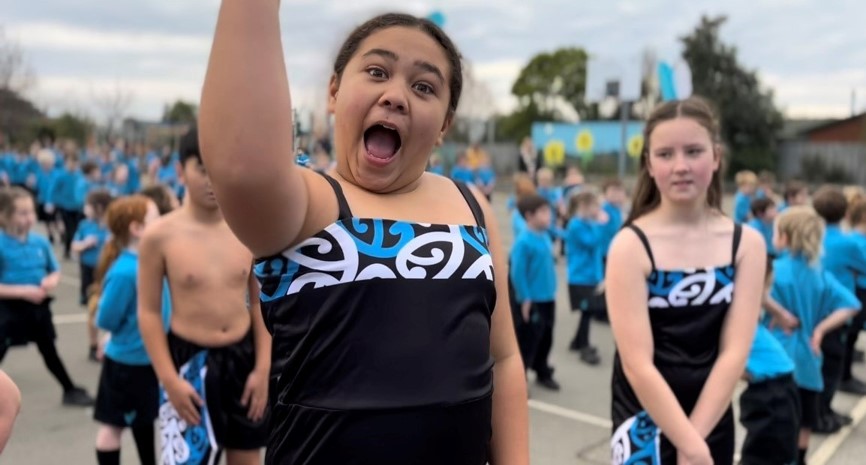 Tamariki looking to camera at a cultural event