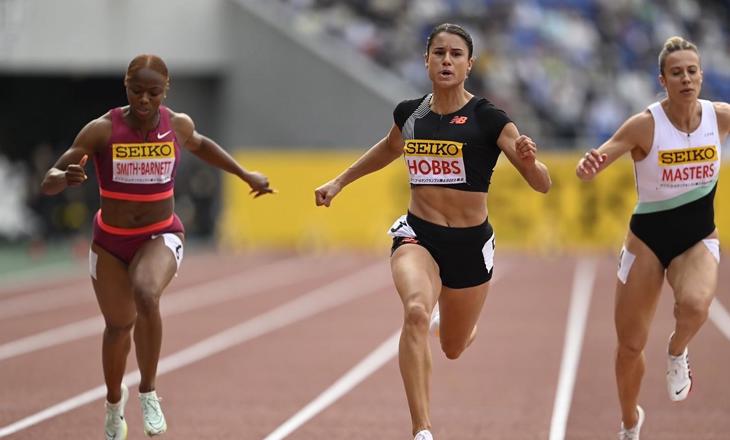 Three athletes running on a track
