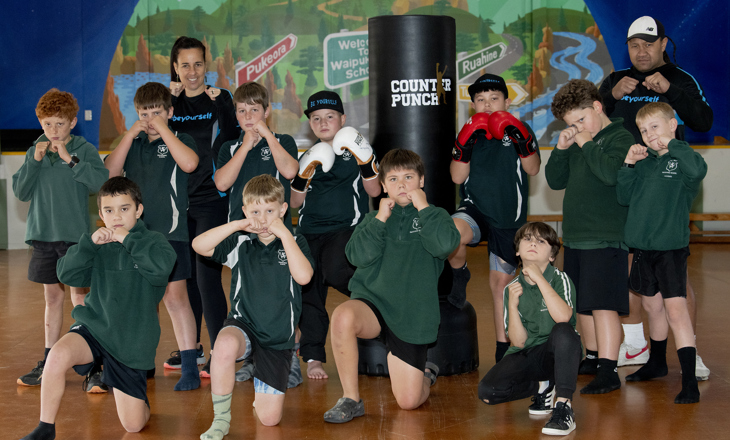 Kids in a boxing class looking to the camera
