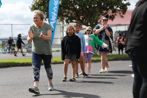 Māori wahine and tamariki clapping and walking on the street