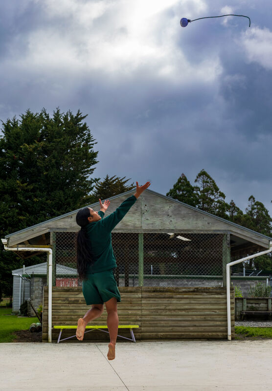 Rangatahi throwing a poi in the air